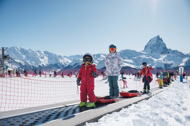 Station d'Artouste enfants sur le tapis avec le Pic du Midi en toile de fond ©Hugo Aussenac