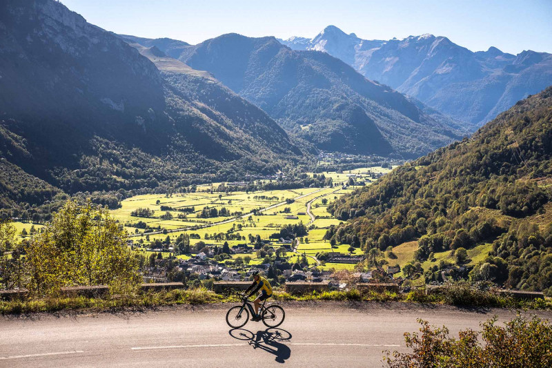 Cycliste sur la route du plateau du Bénou avec vue sur la Vallée d'Ossau