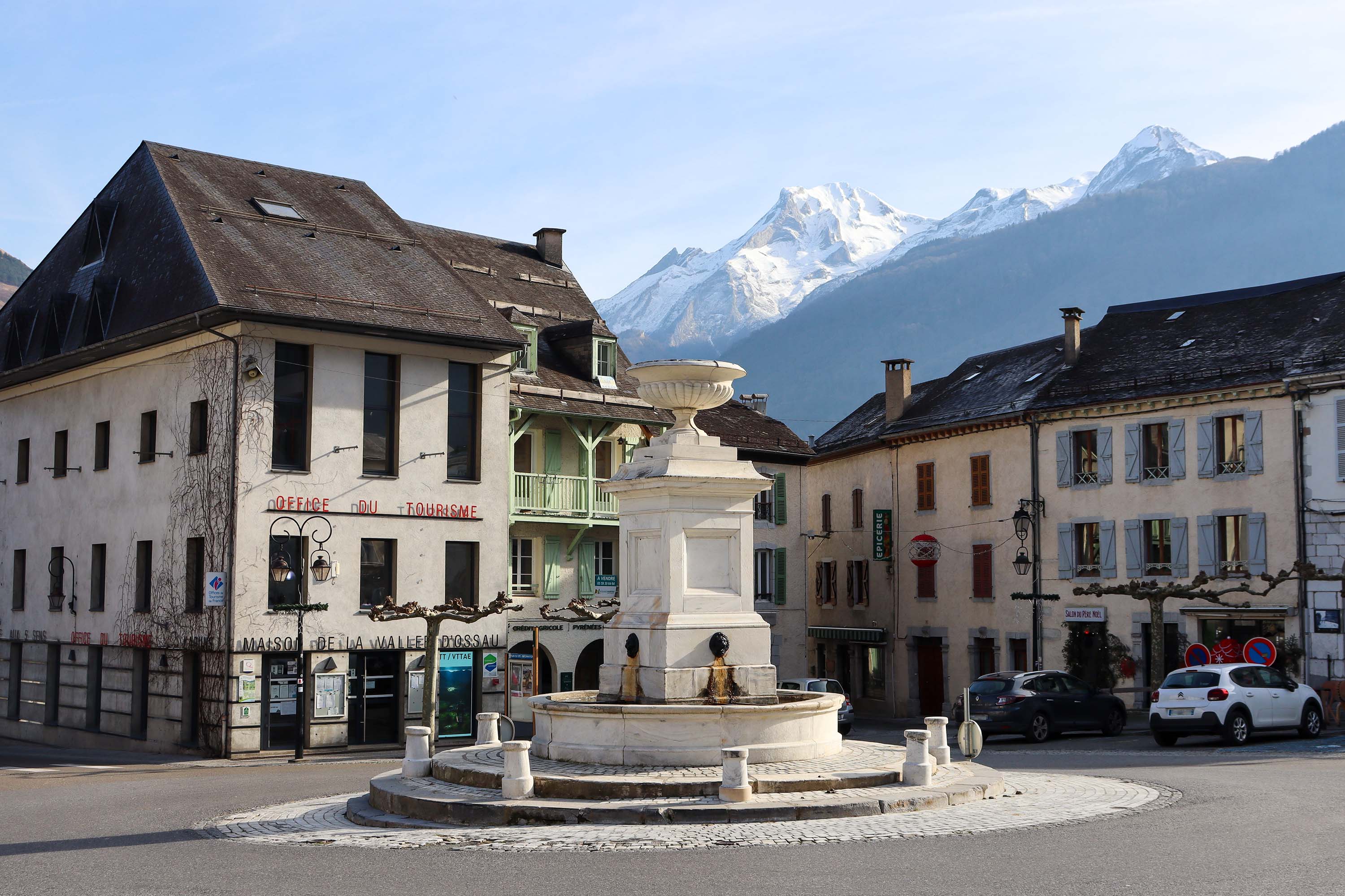 Place de Laruns, au centre la fontaine en marbre de Louvie-Soubiron et en toile de fond le Pic du Ger - © otvo 
